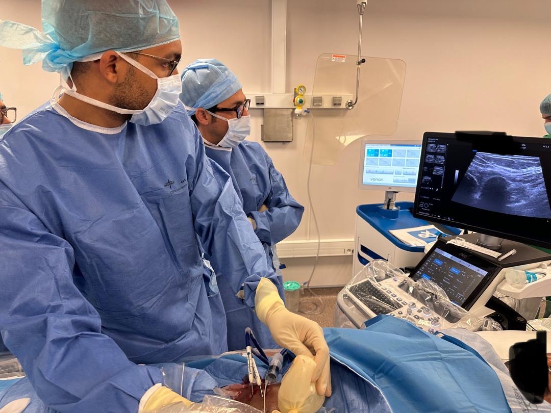 Équipe de radiologie interventionnelle réalisant un geste sous guidage échographique